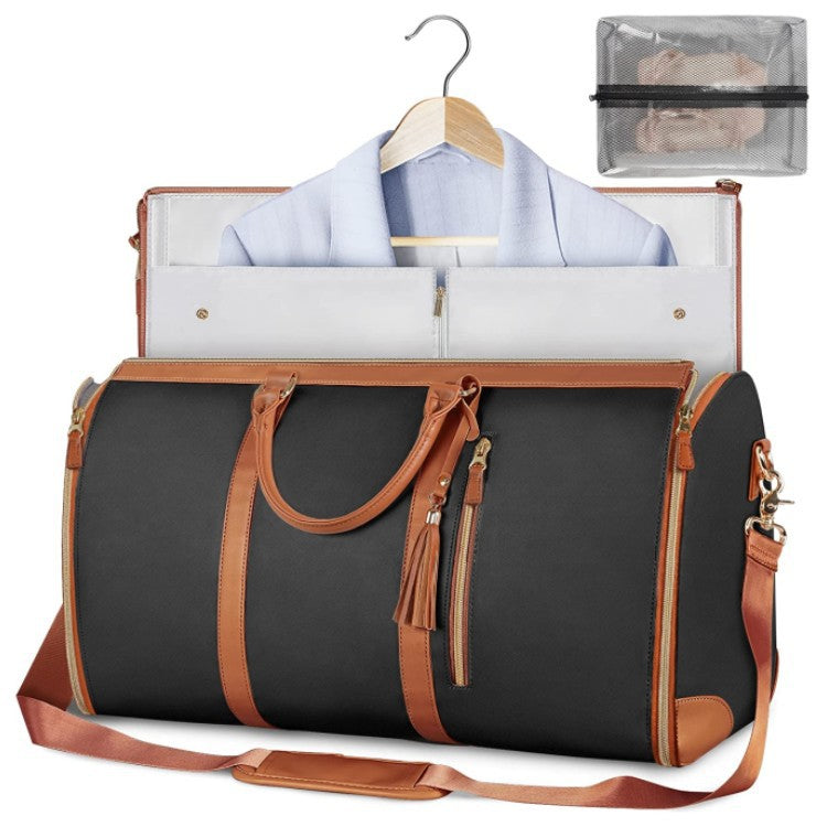 Black duffel bag with brown leather straps and trim, open to reveal a shirt on a hanger and a clear pouch.